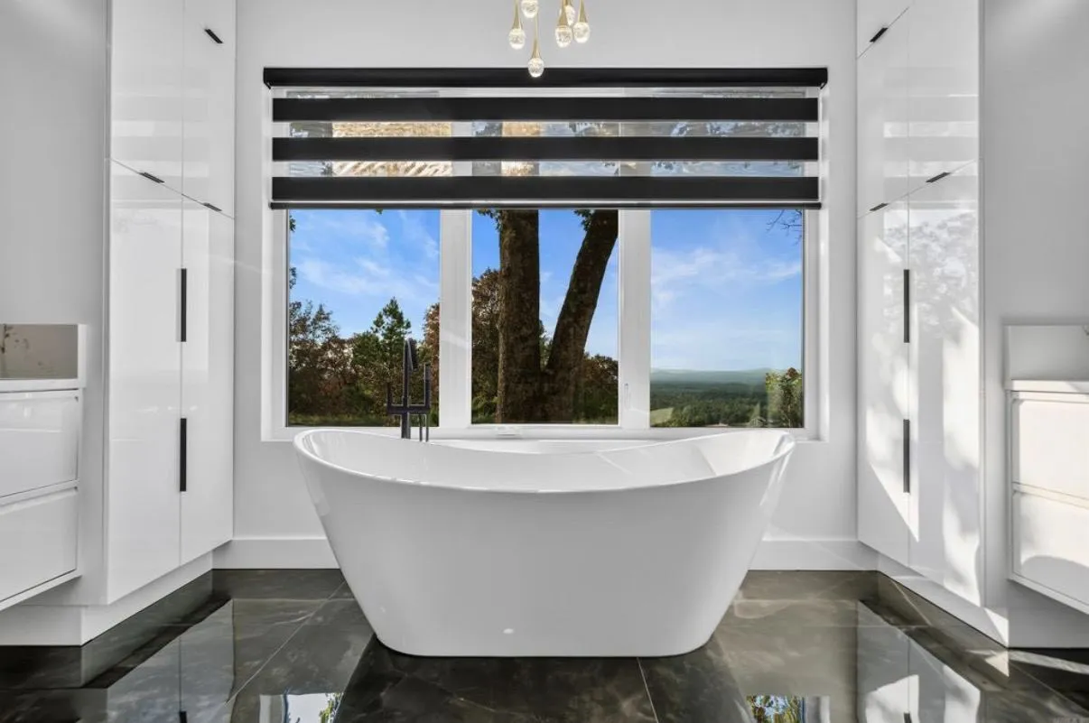 Primary bath with soaking tub, black marble floor, and hex shower pan