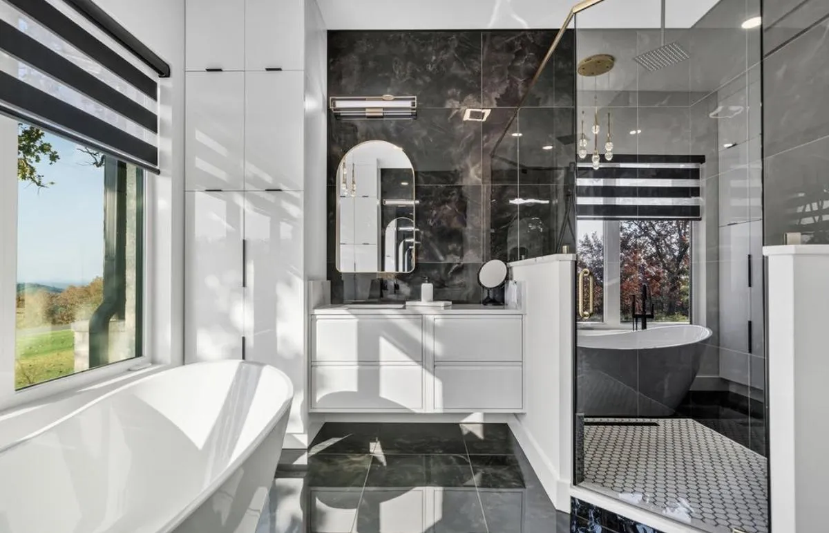 Primary bath with a glass-enclosed walk-in shower in black marble-look tile